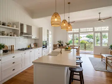 Open-plan kitchen in a renovated Queenslander with VJ walls and hoop pine floors