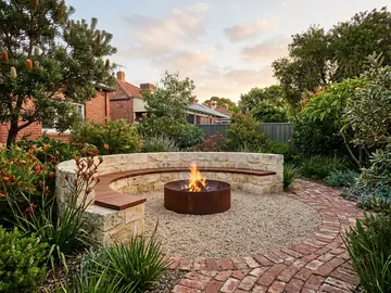 Gravel courtyard with a steel fire pit and built-in limestone bench seating